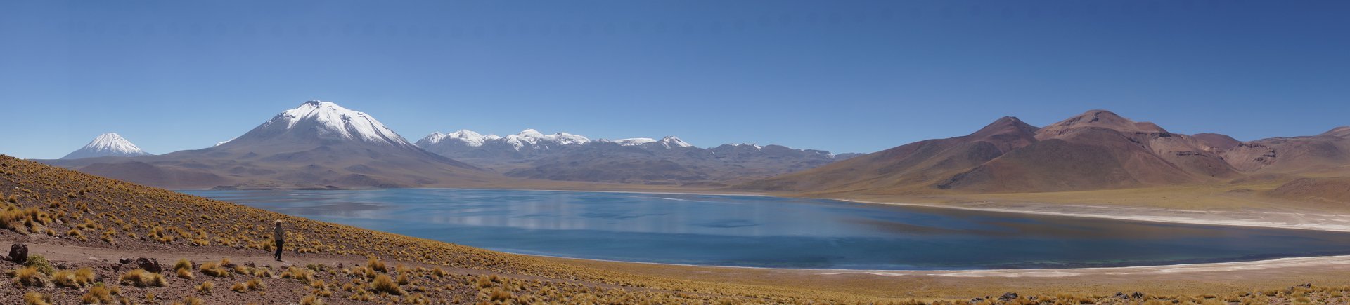 Lagune d'altitude bleue au pied de volcans enneigés